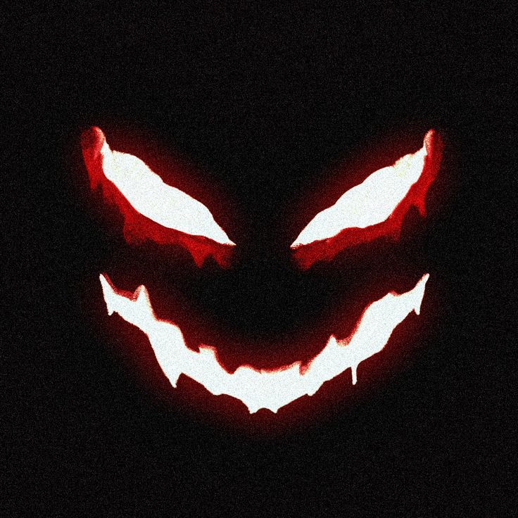 a scary face with glowing teeth in the dark