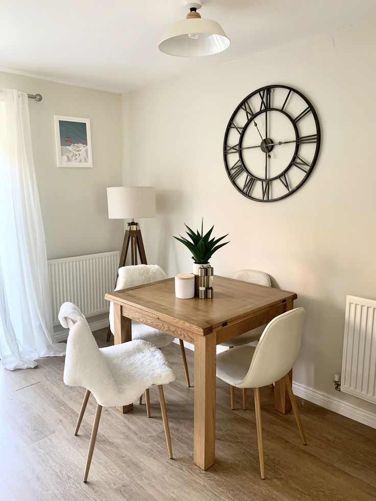 a table with chairs and a clock on the wall