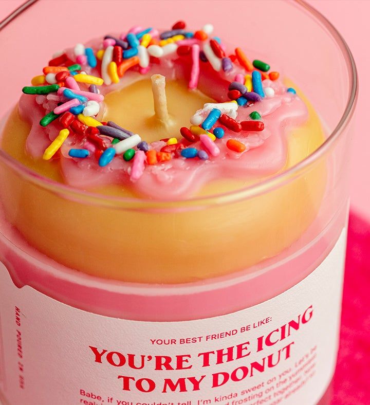 a frosted donut with sprinkles on it in a glass container