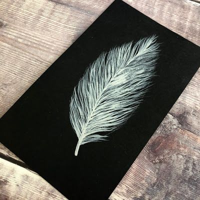 a black card with a white feather on it