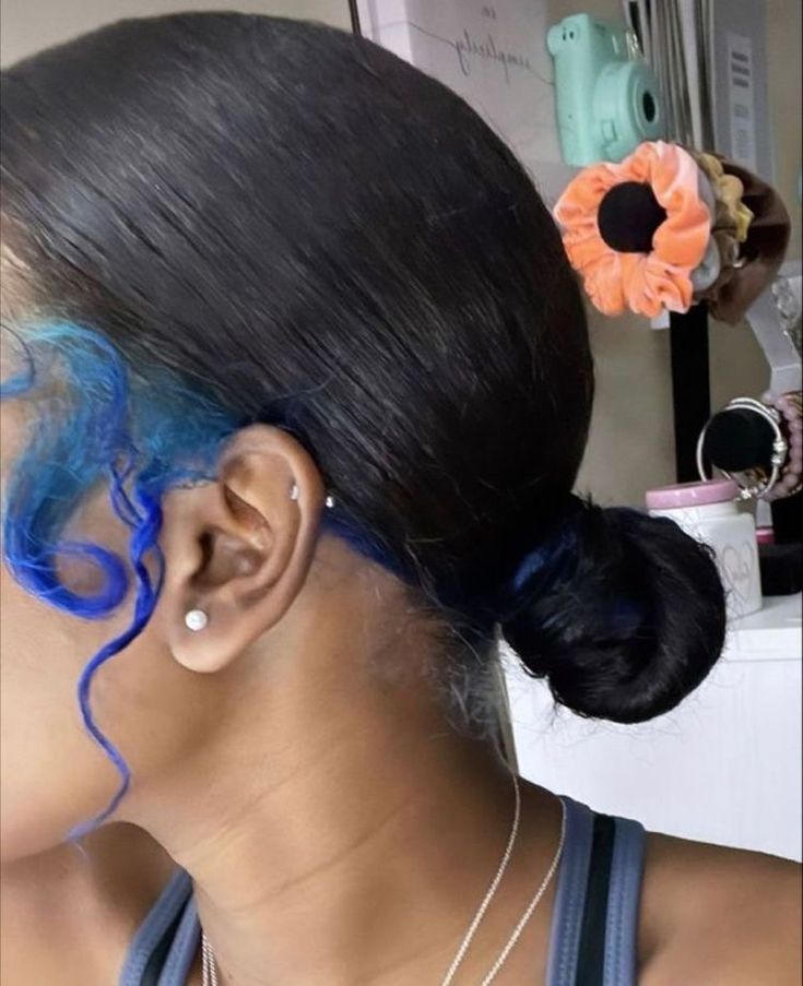 a woman with blue hair and an orange flower in her hair