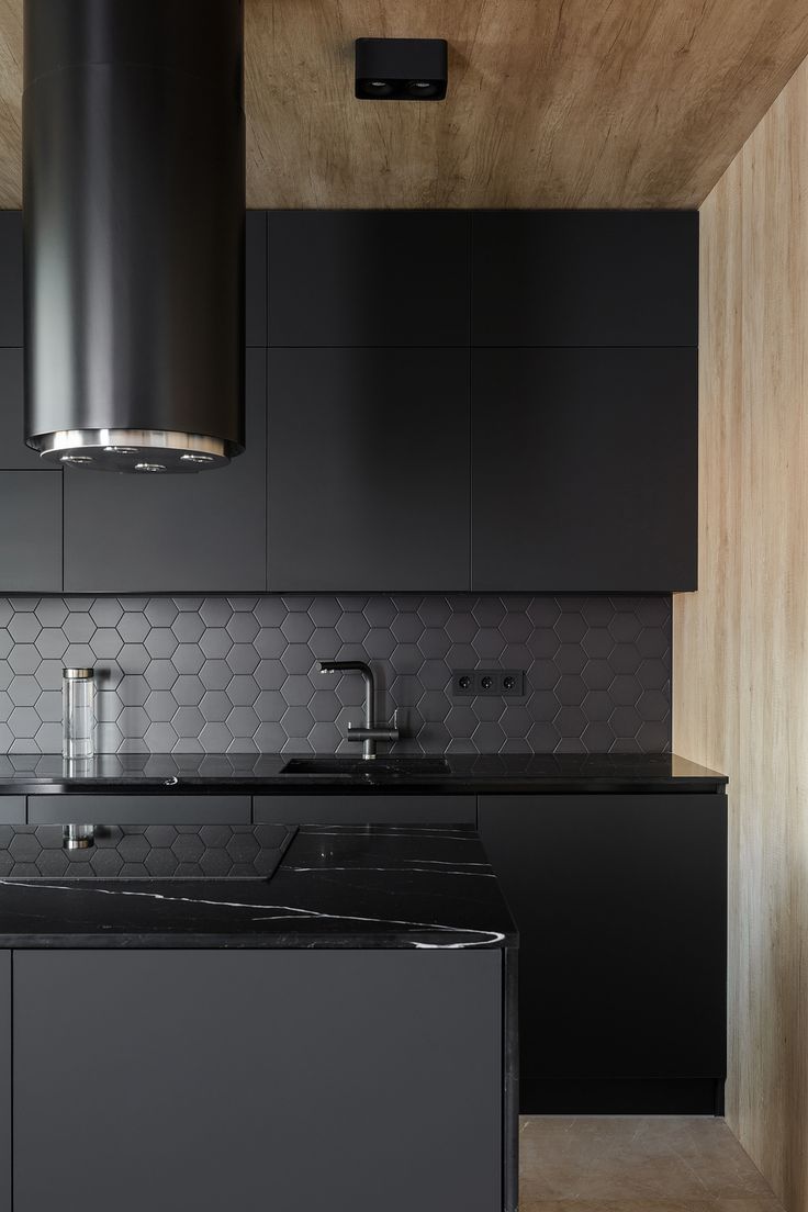 a kitchen with black cabinets and counter tops