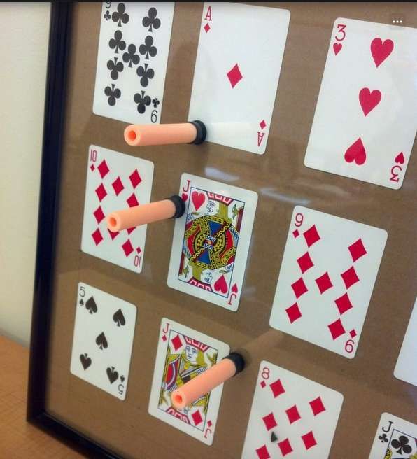 a framed playing card game with fours and fives on the cards, in front of a white wall