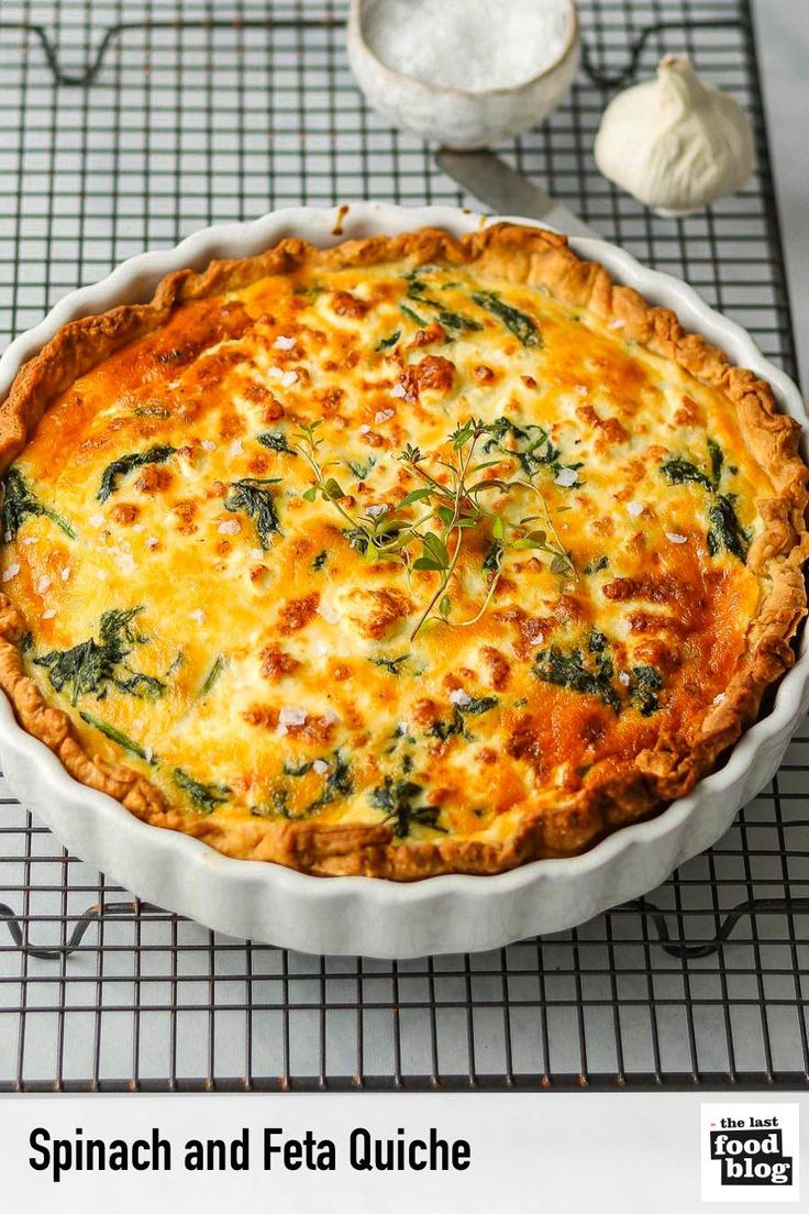 spinach and feta quiche in a white pie dish on a wire rack