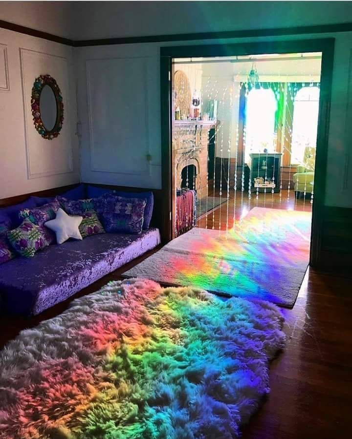 a living room filled with furniture and rainbow rugs