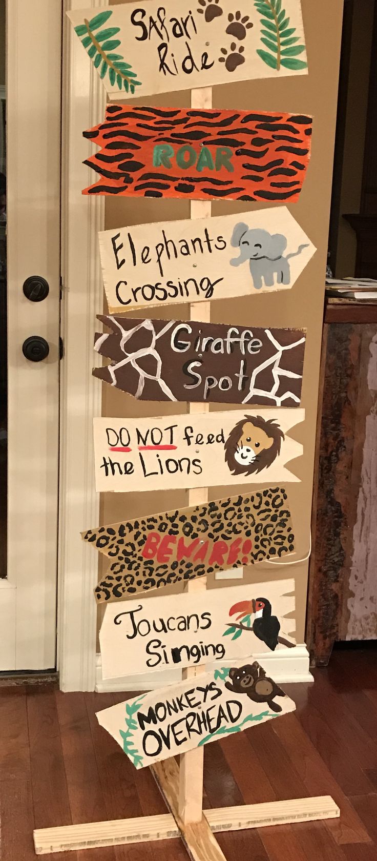 a wooden sign with many different types of signs on it in front of a door