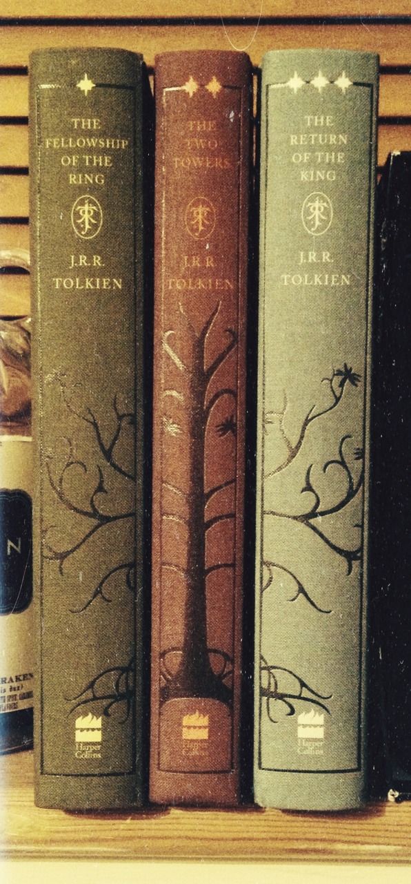 three books sitting on top of a wooden shelf