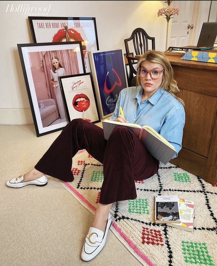 a woman sitting on the floor holding a book