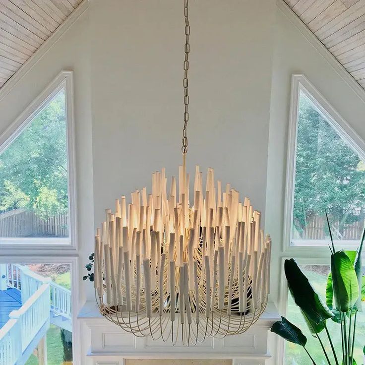 a chandelier made out of bamboo sticks hanging from the ceiling in a living room