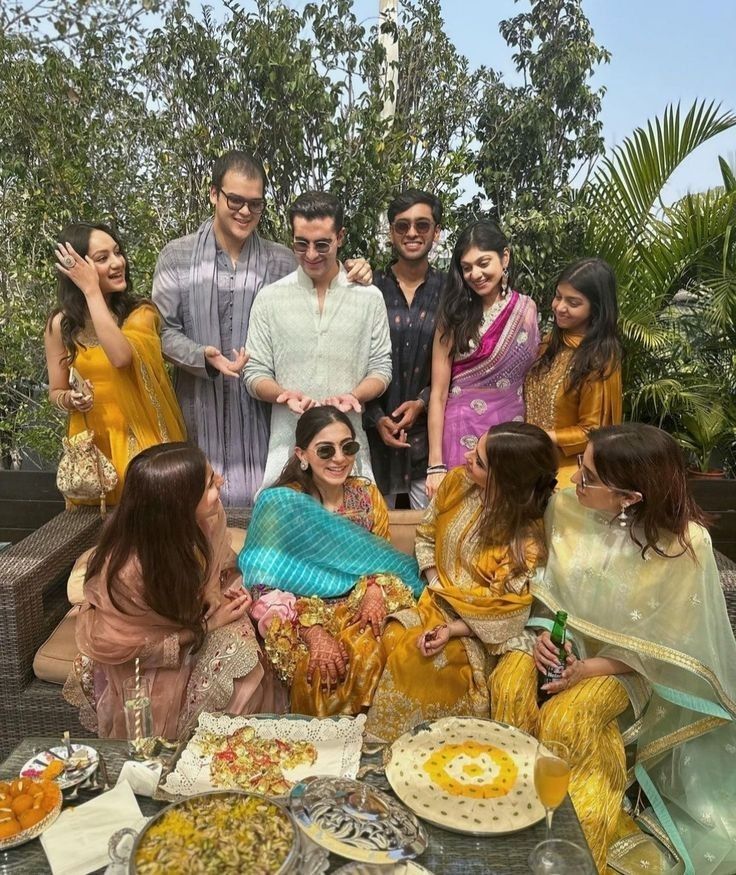 a group of people standing around a table covered in food