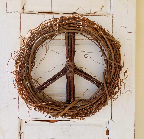 a peace sign made out of twigs hanging on a wall