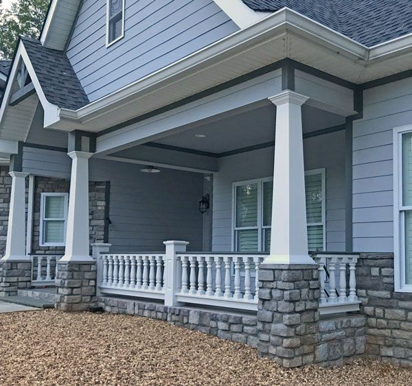 a gray house with white pillars and windows