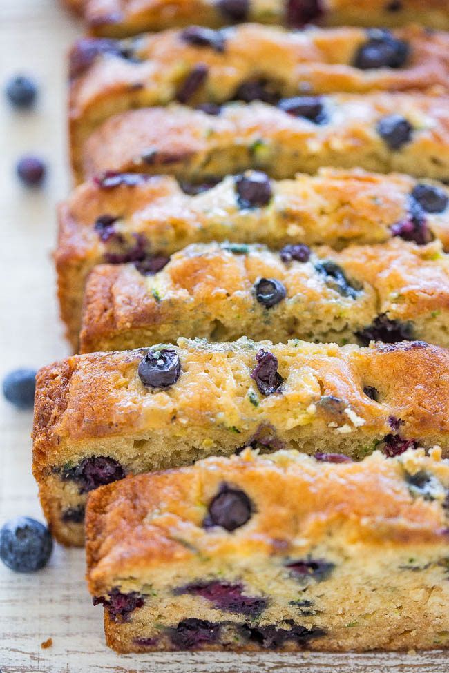 slices of blueberry bread are lined up on a cutting board