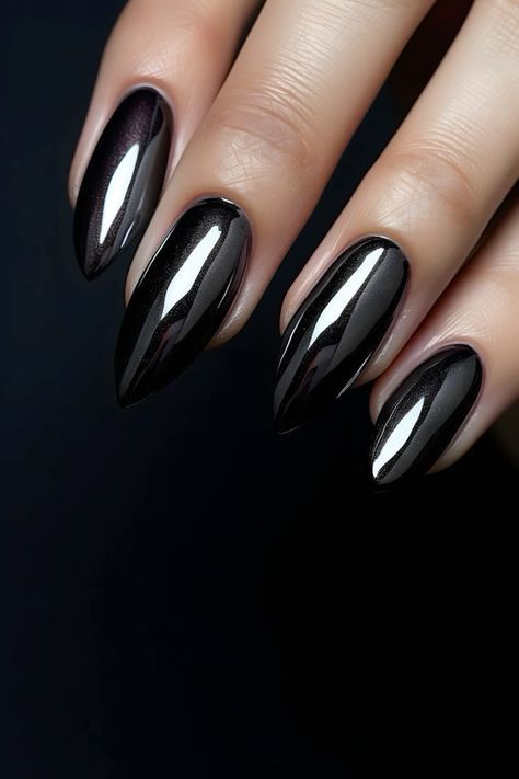 a woman's hand with black and silver nail polishes on her nails,