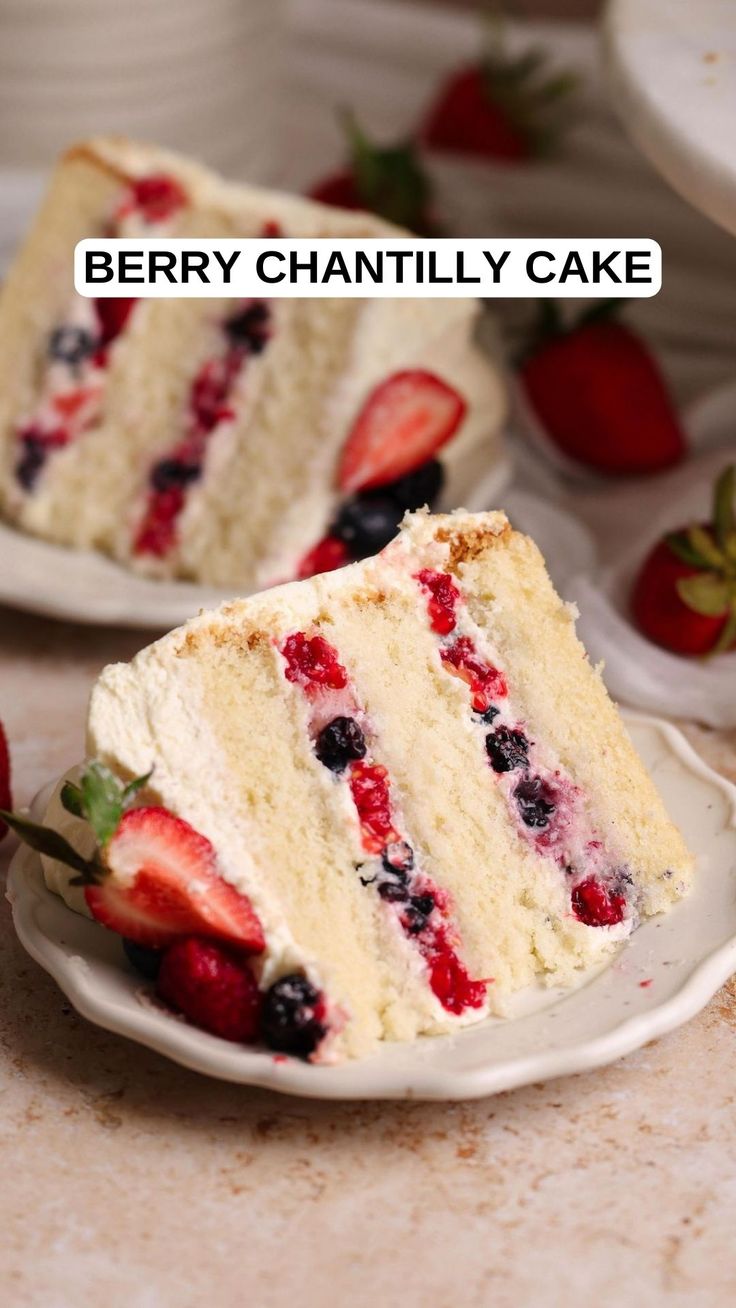 two slices of cake on plates with strawberries and blueberries in the middle one slice is missing