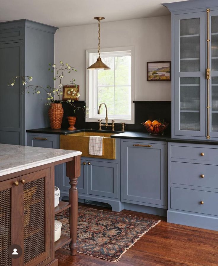 a kitchen with blue cabinets and wooden floors