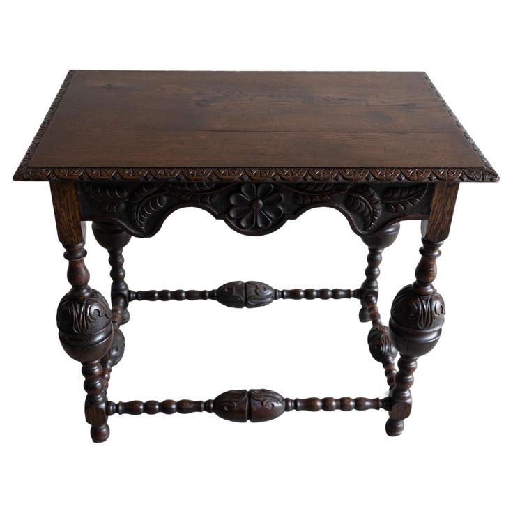 an old wooden table with ornate carvings on the top and bottom, against a white background