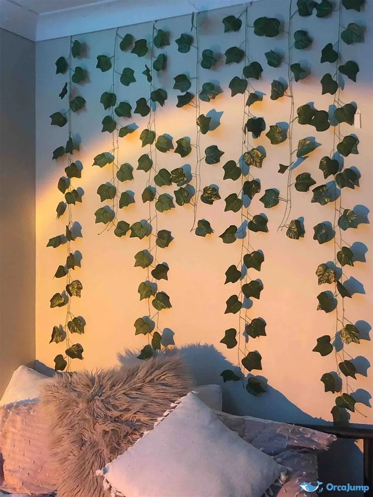 a bed with pillows and some plants hanging from the headboard on it's wall