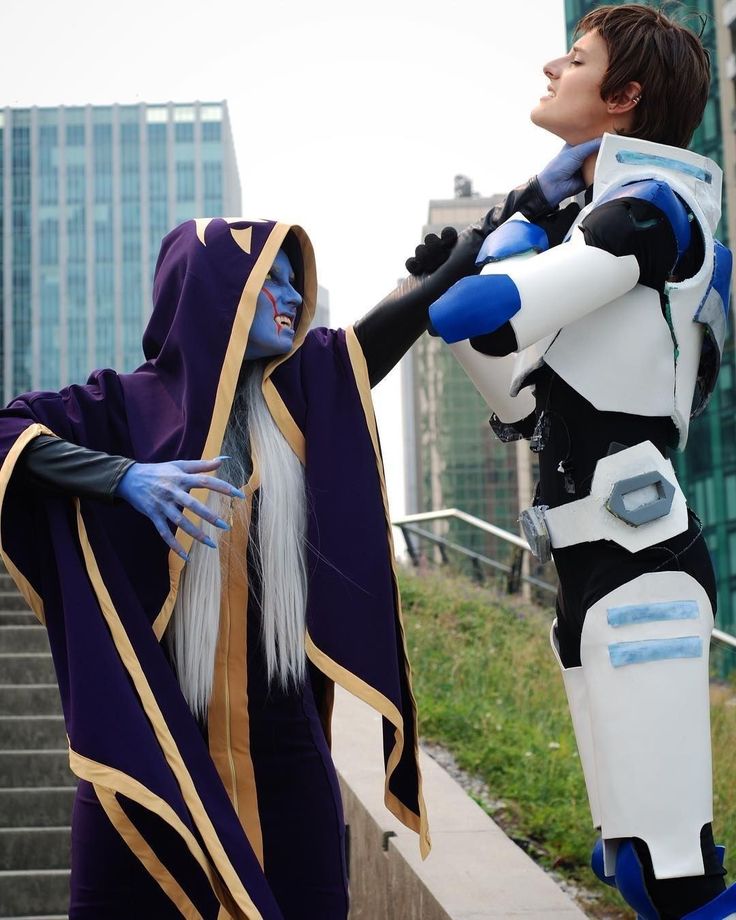 two cosplayes dressed in costumes standing next to each other