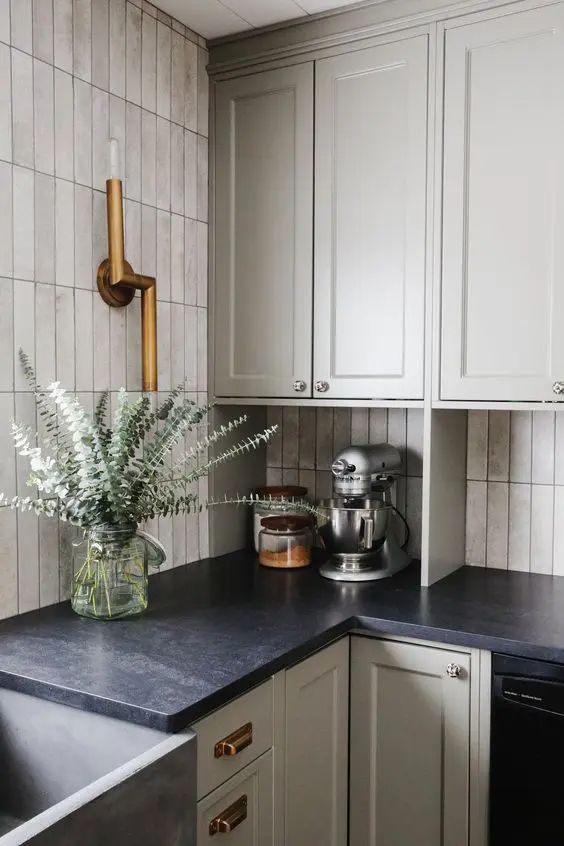 a dove grey shaker style kitchen with a skinny tile backsplash, black soapstone countertops and brass fixtures Small Mid Century Kitchen, Colors For Small Kitchen, Kitchen Gray Countertops, Farmer Kitchen, Black Kitchen Countertops, Century Farmhouse, Dark Countertops, Black Countertops, Grey Countertops