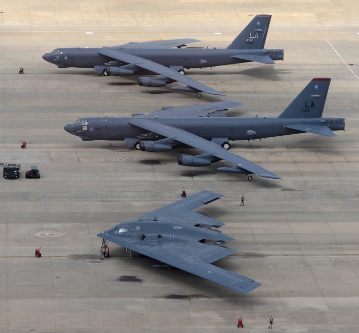 two fighter jets sitting on top of an airport tarmac