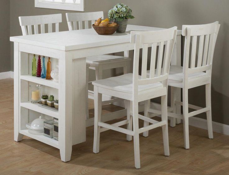 a white dining table and chairs in a room