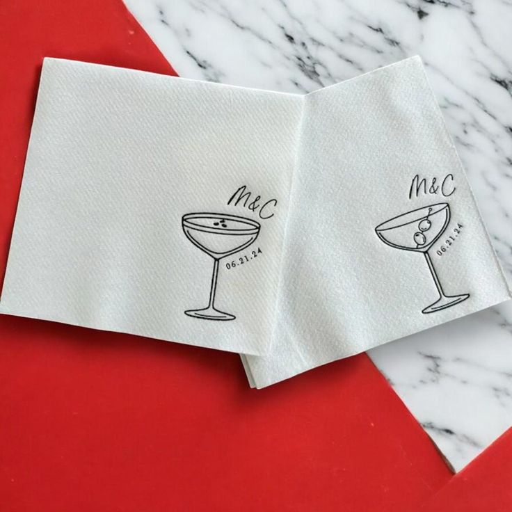 two napkins with the words mac and a martini glass drawn on them, sitting next to each other