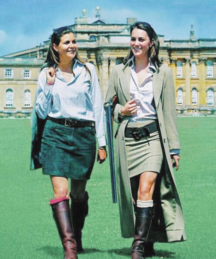 two women walking in front of a large building