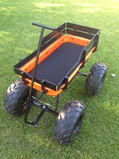 an orange and black cart on some grass