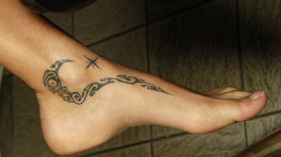 a woman's foot with a tattoo on the top and bottom of her leg