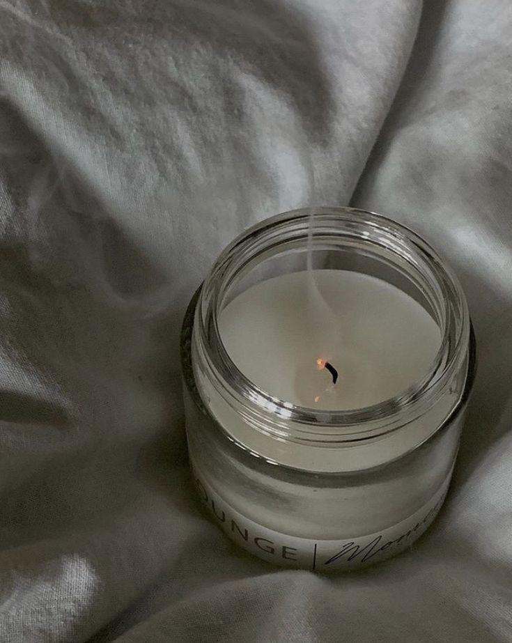 a candle that is sitting on a bed