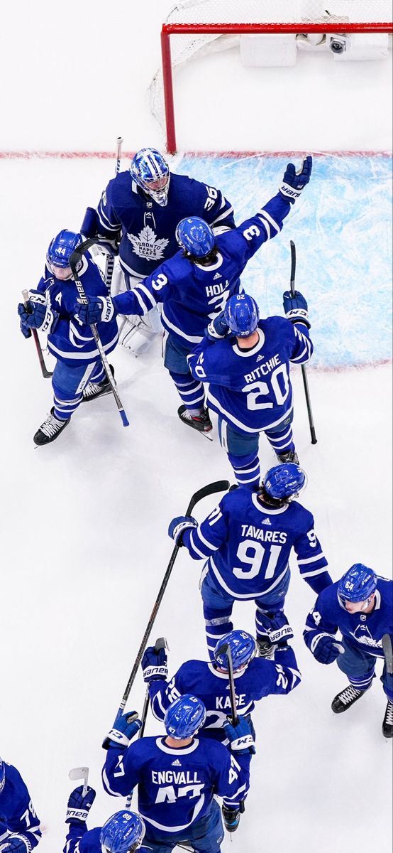 a group of young men standing on top of a ice hockey rink next to each other