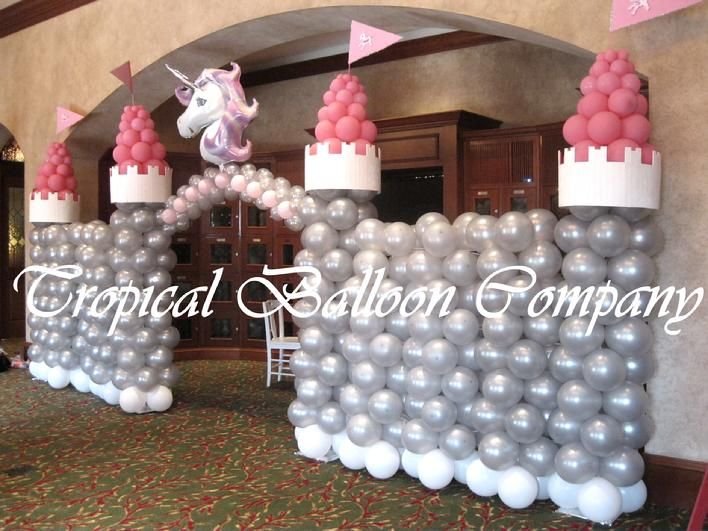 an inflatable balloon castle with a unicorn on top and balloons all around it