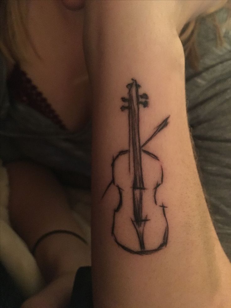 a woman's arm with a violin tattoo on it