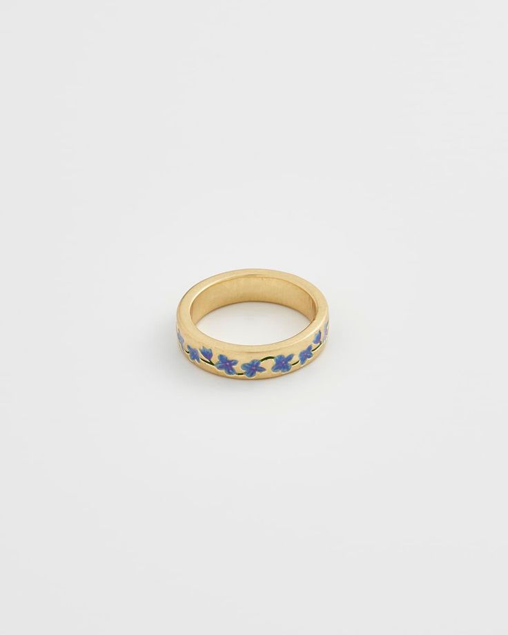 A dainty gold band adorned with delicate hand-painted enamel Forget Me Not flowers, encircling it in a timeless embrace. This ring captures the essence of everlasting love and the enduring beauty of nature.  Key features:   Hand-painted enamel  18K Worn-gold plated brass, enamel  5mm width band; 2mm thick-rounded  Small: US6, Circumference 52mm, UK L1/2  Medium:US 7, Circumference 55mm, UK N 1/2  Large: US 8, Circumference 57mm, UK P 1/2  Comes in a gift box with cotton pouch      Size: Small, M Forget Me Not Ring, Dainty Gold Band, Forget Me Not Flowers, Dope Jewelry, Jewelry Lookbook, Everlasting Love, Cheese Ball, Put A Ring On It, Forget Me Not