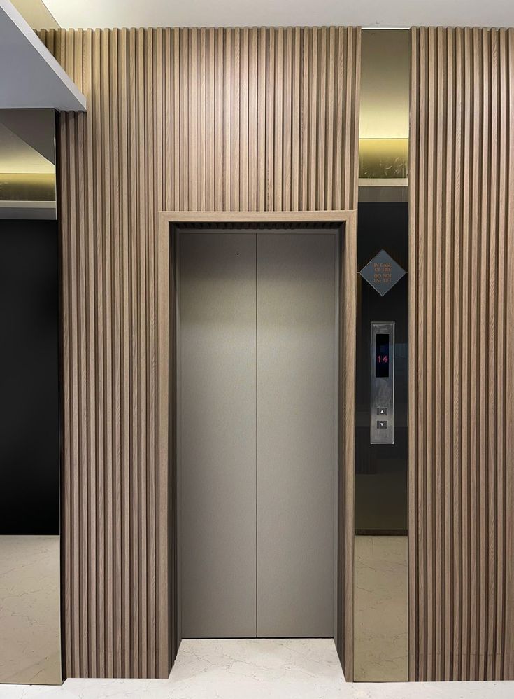 an empty elevator with wooden slats on the walls and doors open to let in light