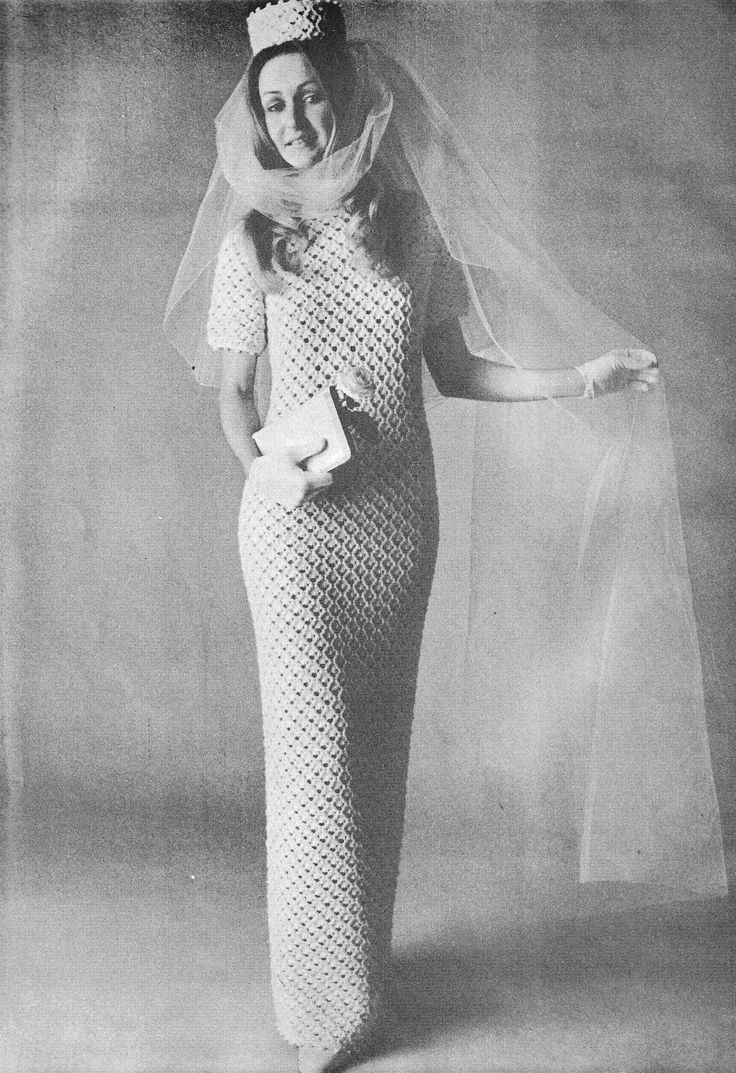 a woman in a crochet dress and veil poses for the camera with her hands on her hips