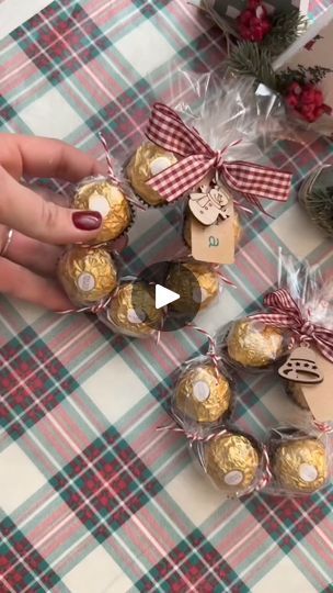 chocolates wrapped in cellophane and tied with bows are displayed on a table