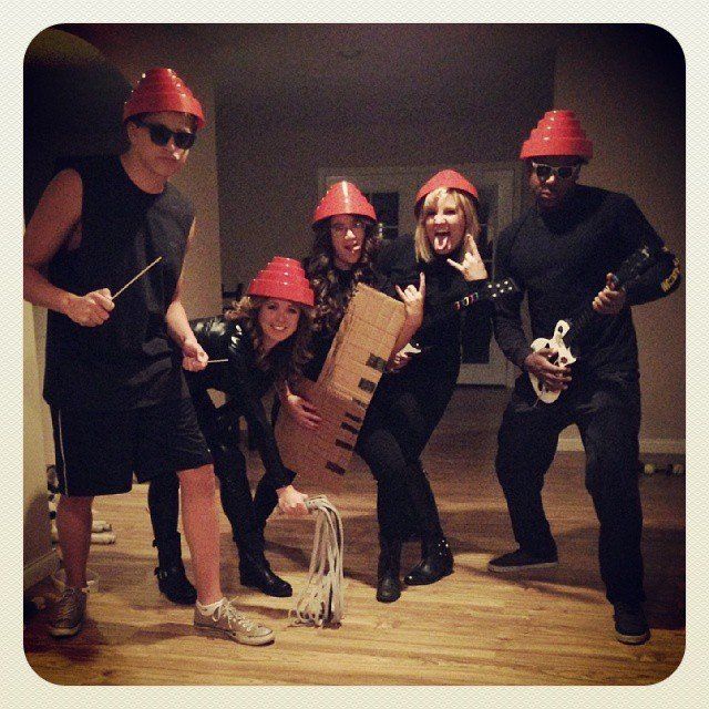 a group of people wearing red hats and holding cardboard boxes on their heads while posing for the camera