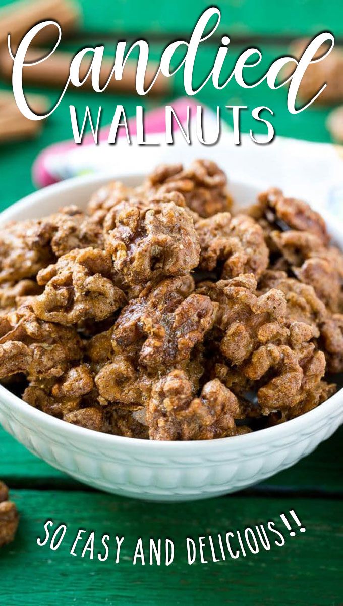 a white bowl filled with candied walnuts on top of a green wooden table