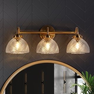 a bathroom vanity with three lights and a mirror on the wall next to a potted plant