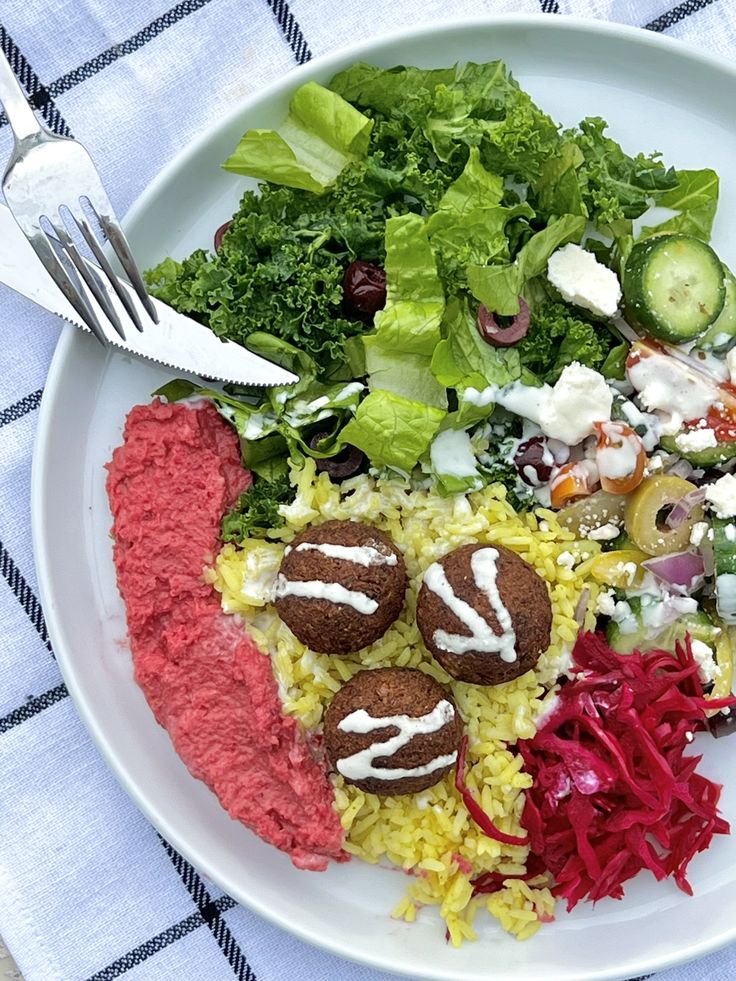 a white plate topped with meat and veggies on top of a checkered table cloth