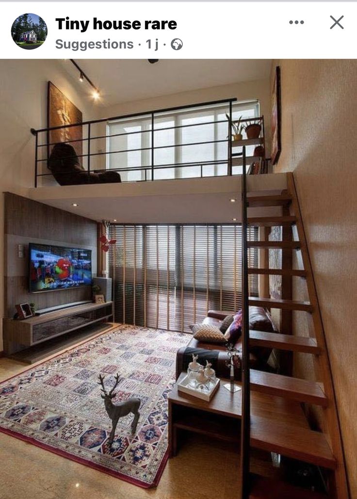 a living room with stairs leading up to the top floor and a loft bed above it