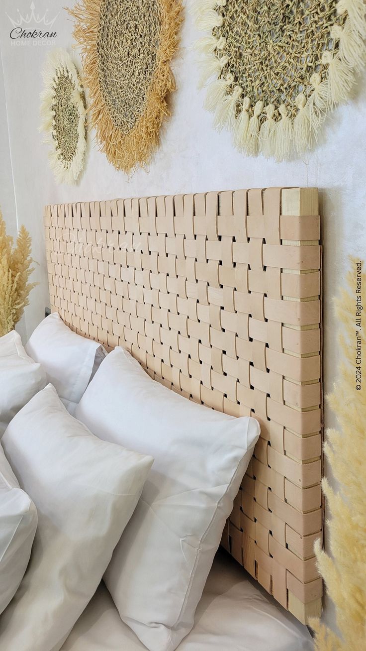 a bed that has some pillows on top of it and two wall hangings above the headboard