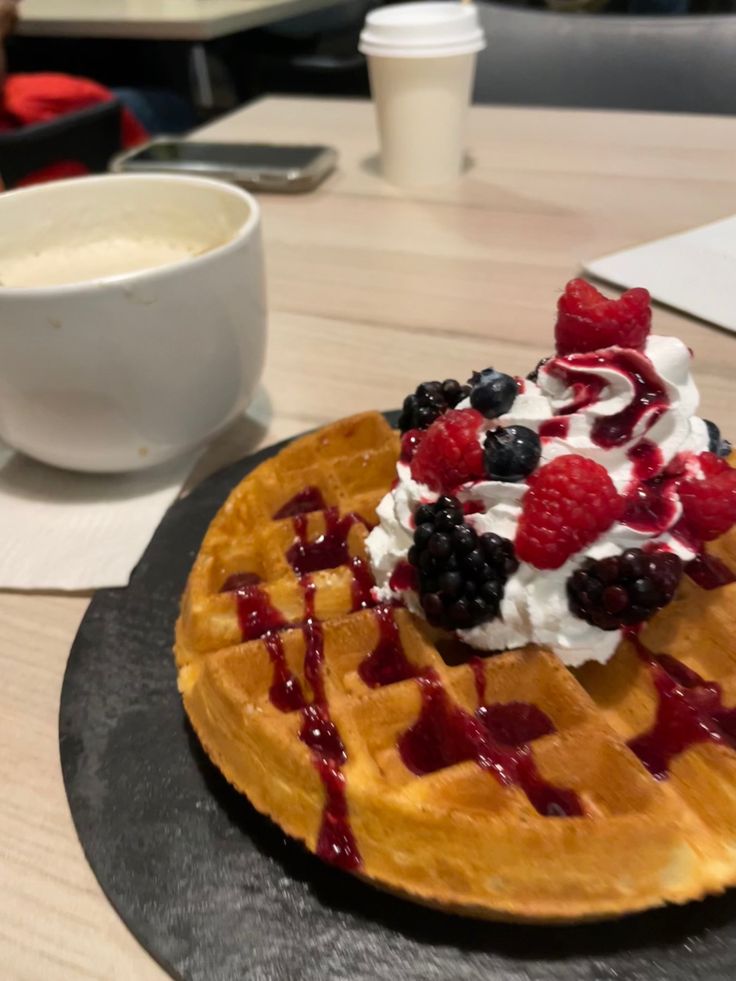 a waffle topped with berries and whipped cream