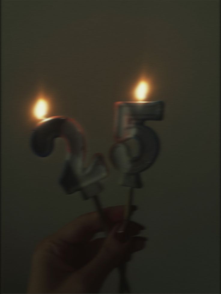 a person holding two candles in the shape of numbers