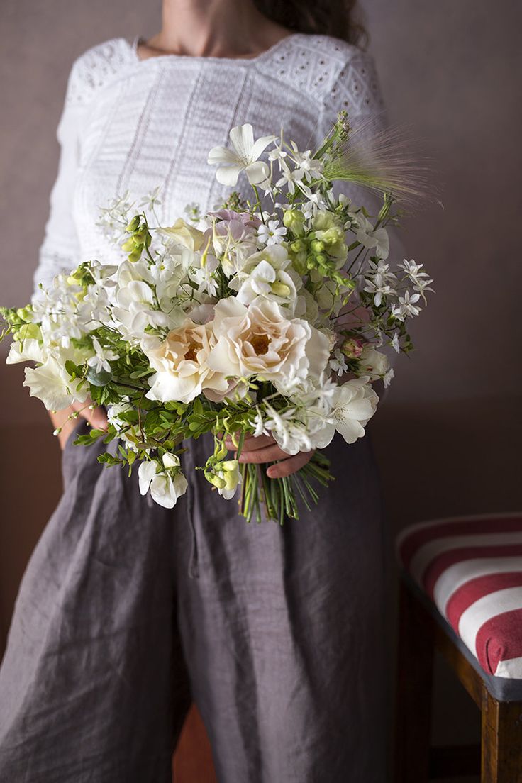 a woman holding a bouquet of flowers in her hands