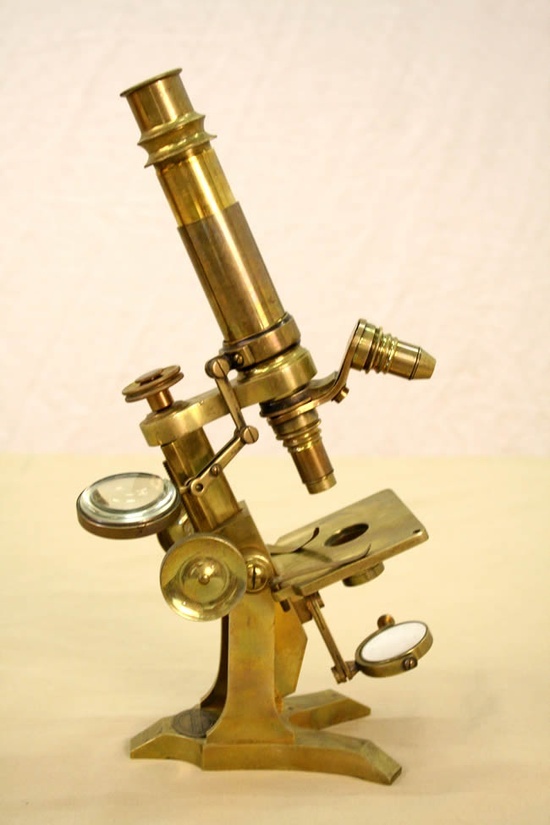 an old brass microscope with two magnifying glasses