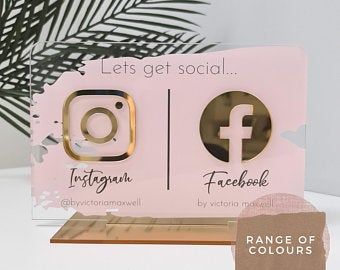 two pink and gold facebook logo magnets on a white table with palm tree in the background