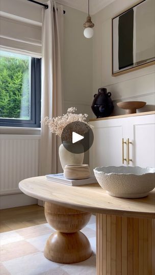 a table with a bowl on it in front of a window